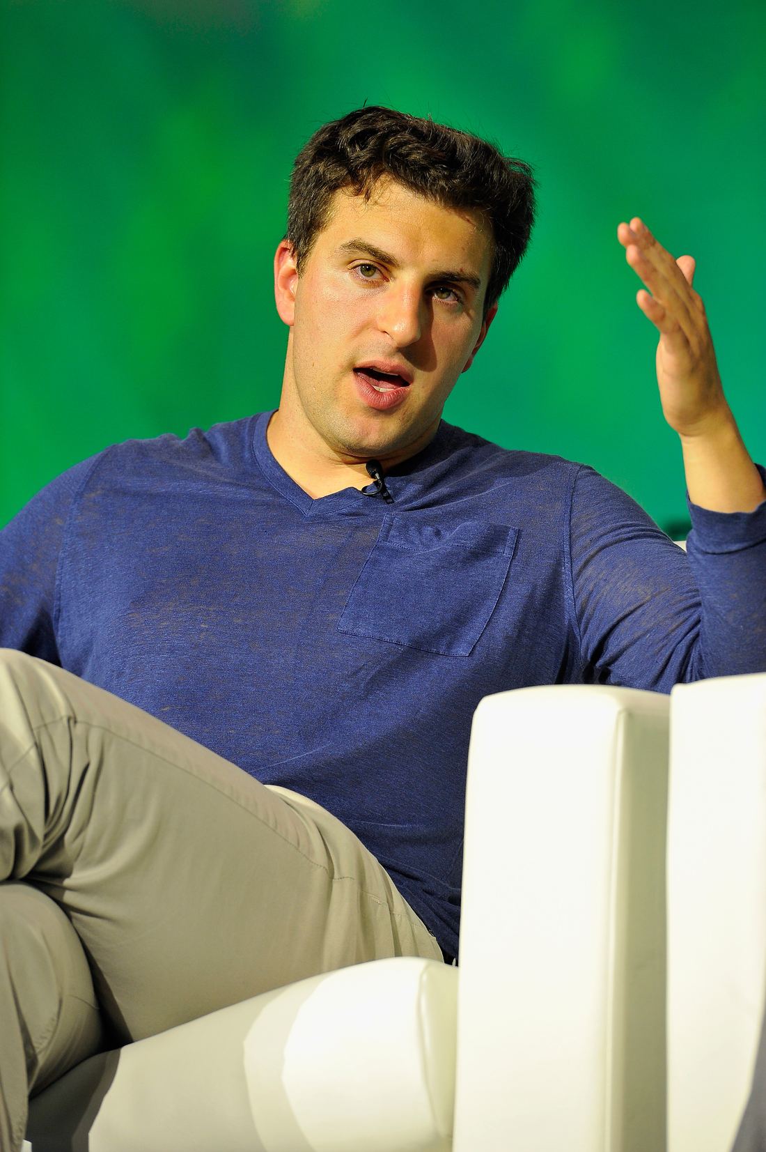 Airbnb co-founder Brian Chesky speaking on stage at a TechCrunch event