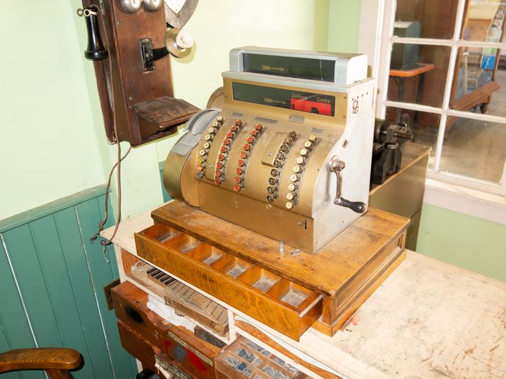 Ornate antique brass cash register on display at a heritage museum