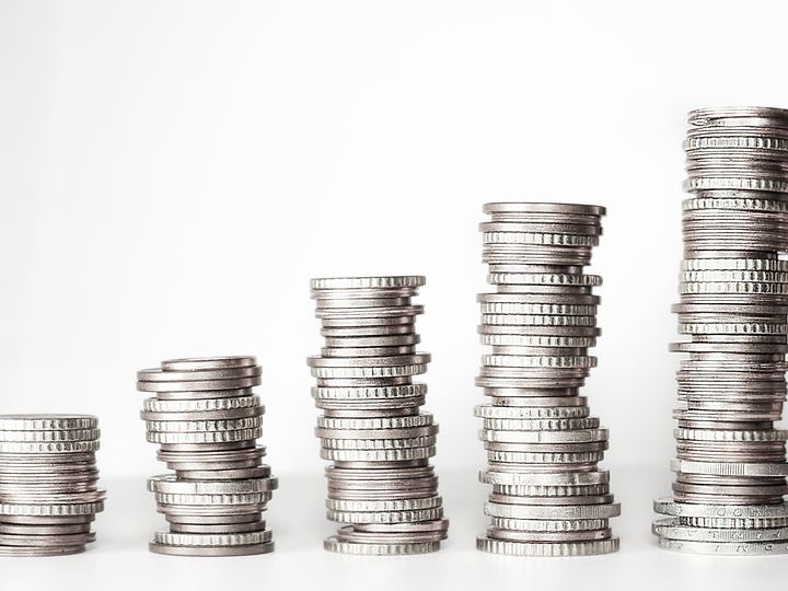 Five stacks of coins of increasing height on a table